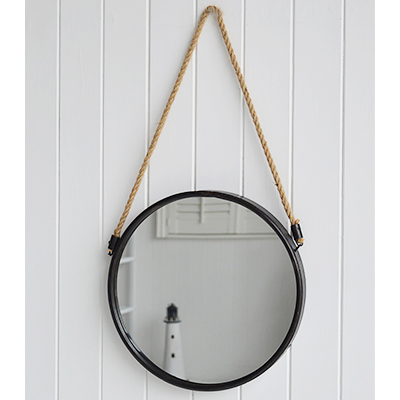 A circular porthole style mirror on a rope with aged dark grey metal surround.

Gorgeous in a coastal bathroom or hanging above a dressing or console table