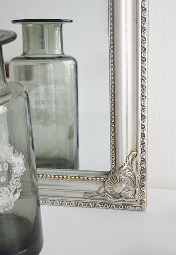 Close photograph of ornate silver mirror on the dressing table