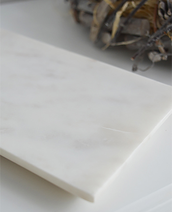 A white marble tray, ideal to let the hair straighteners cool or group together toiletries for a display