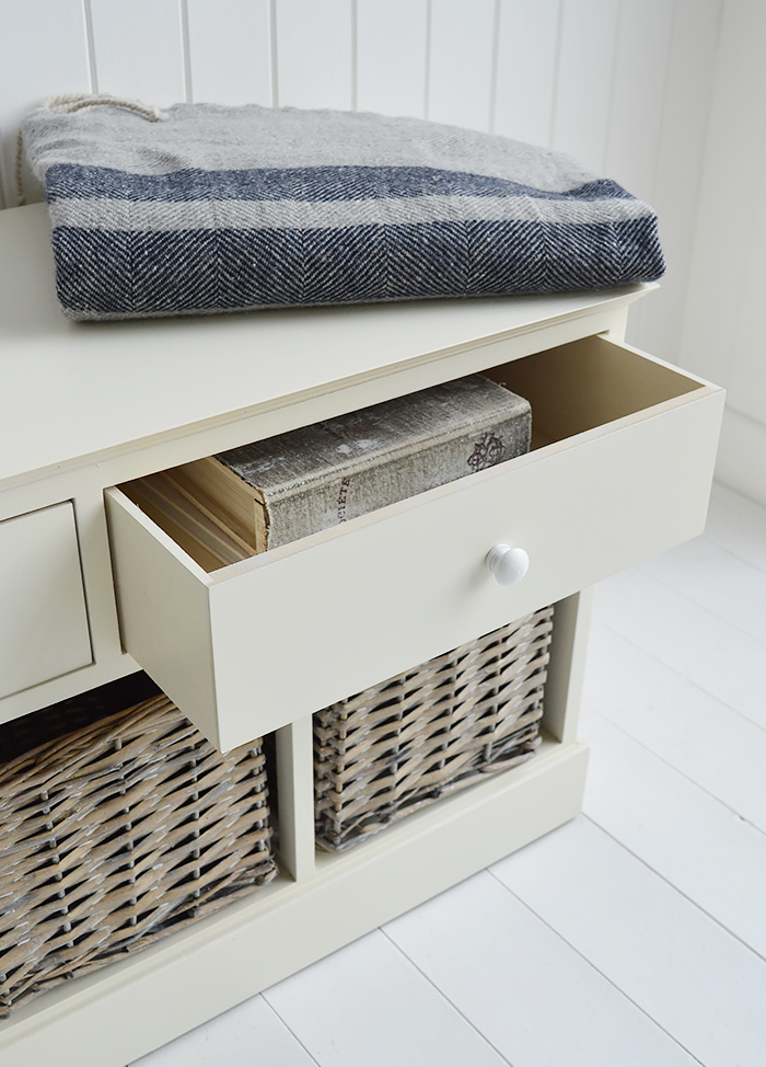 The large top drawer of the cream storage hall bench with books inside