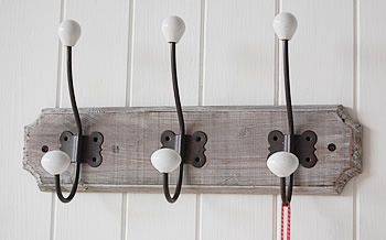 Use rustic greyed washed wood hooks and hangers to keep towels, and coats from the floor 