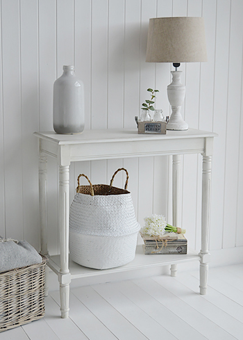 A simple white console table with home decor accessories