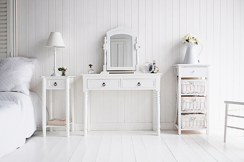 Simply a white bedroom with pieces of furniture