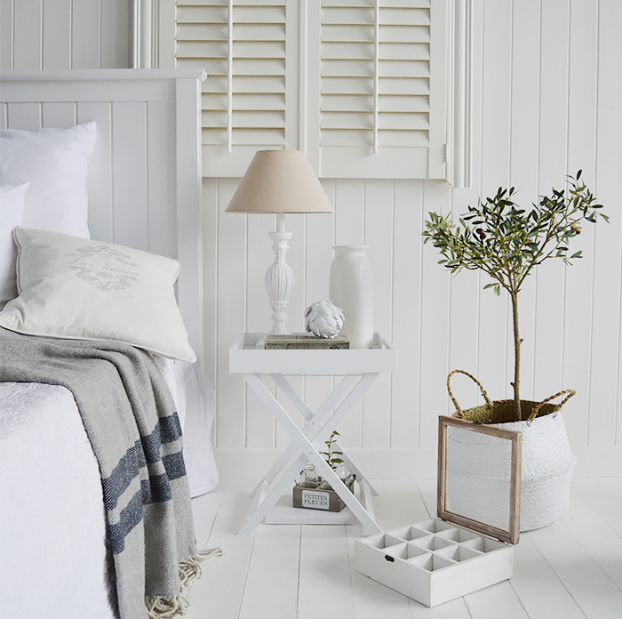 Classic New England style of furniture for the bedroom, adding texture warms the room, giving it a more cosy feel. A touch of greenery gives extra interest. The shutters and white cladding give the traditional look