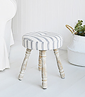 The Long Island small stool, padded and upholstered in ticking linen effect fabric with white washed turned legs for country and coastal home interiors.