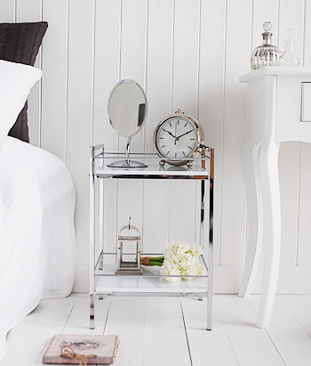 Front image of white and chrome bedside beside a bed and dressing tables showing it is suitable for small spaces