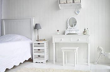 The New England vanity dresser in a pure white bedroom with bedside table, mirror, stool and white accessories