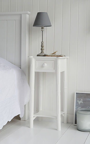 New England bedside table with chunky white handles on the drawers and a shelf