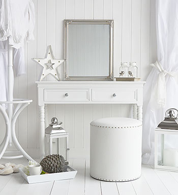 A luxury white bedroom with dressing table and stool