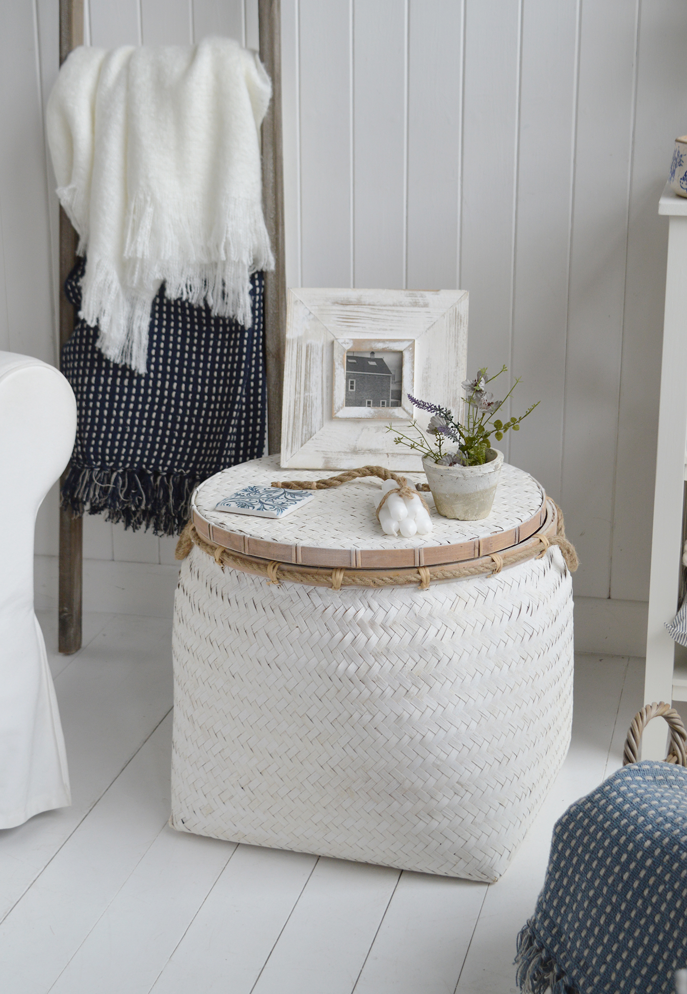 A close image of the Nantucket coastal furniture, an aged white basket table with a lid for great storage