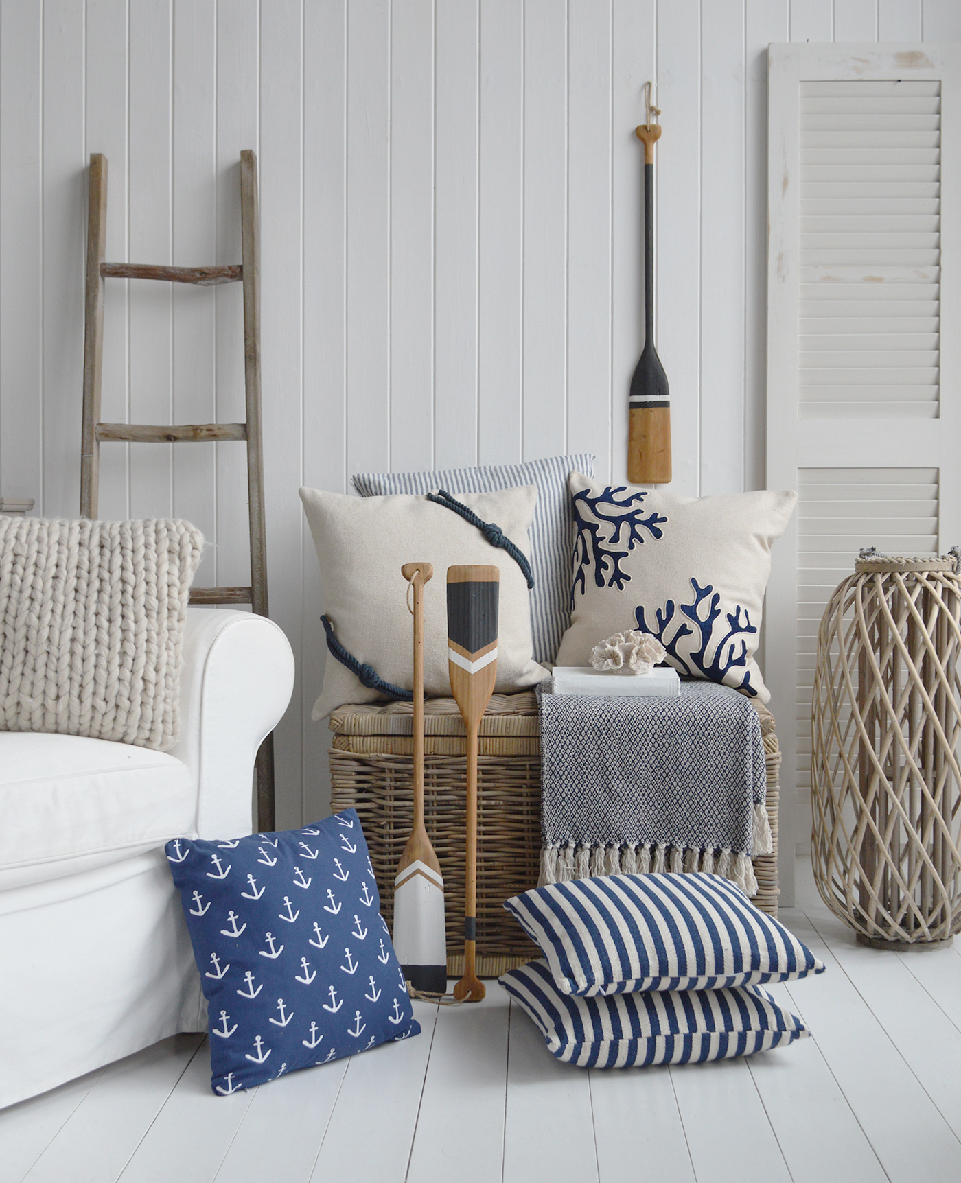 An array of coastal home accessories to use to decorate your seaside holiday home... coastal cushions, wooden lanterns, paddles and faux coral