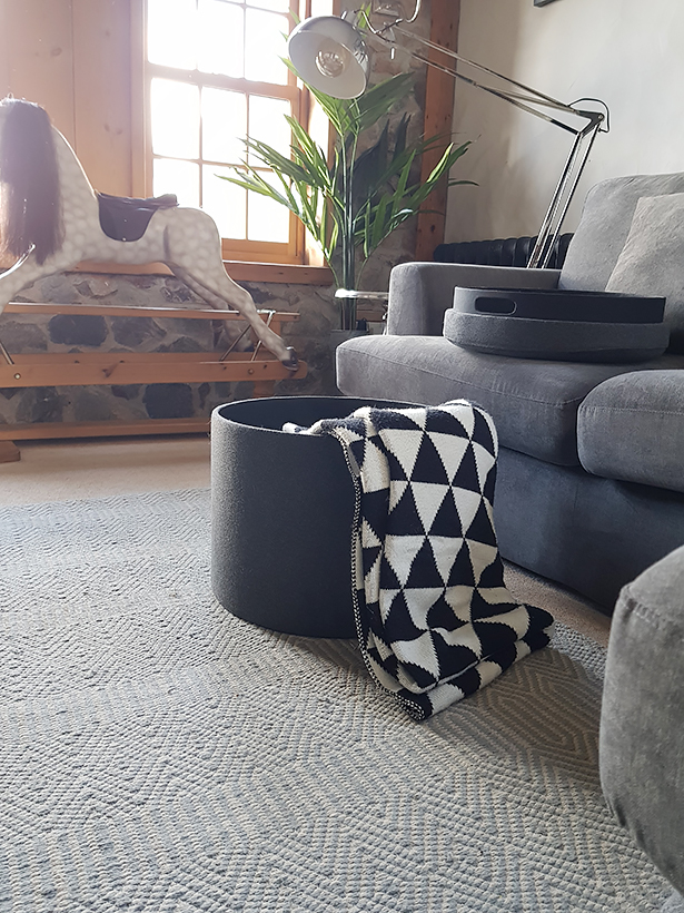 The Grey Westhampton foot stool with storage for blankets and throws with a tray lid in a living room