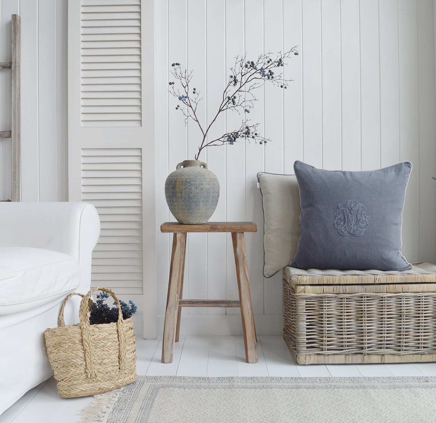 New England interiors for Coastal, modern farmhouse and country styled homes. Shown is the Georgetown stool with the Seaside baskets, Pembroke Vase, Blueberry Branch, monogram cushions and Freeport handled basket in a white living room