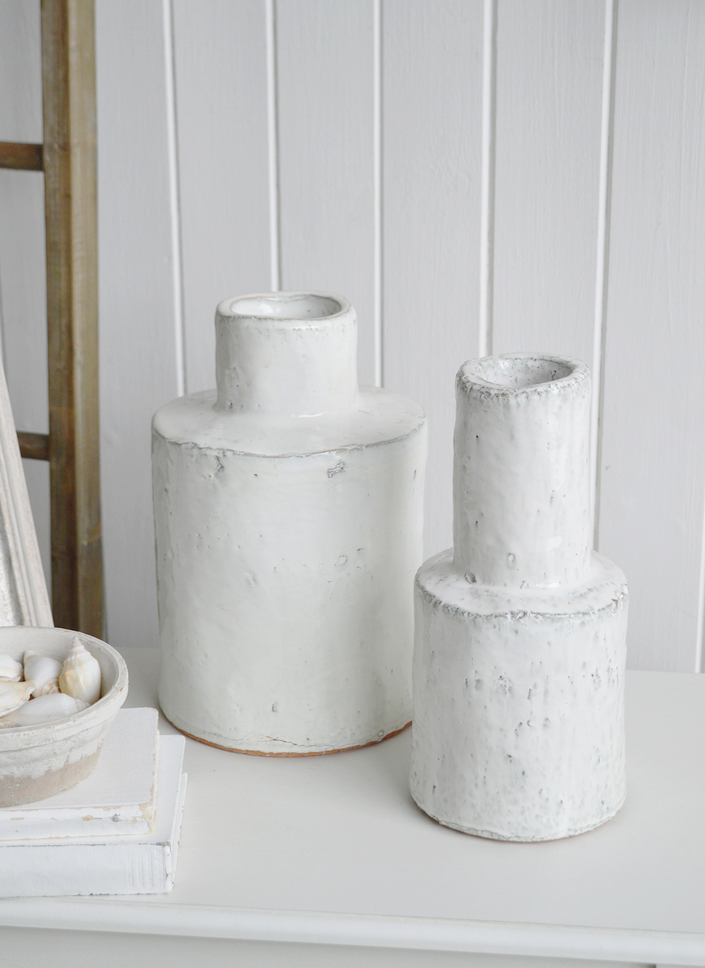 The rustic texture of this ceramic vase makes it a versatile piece for layering within coastal interiors.