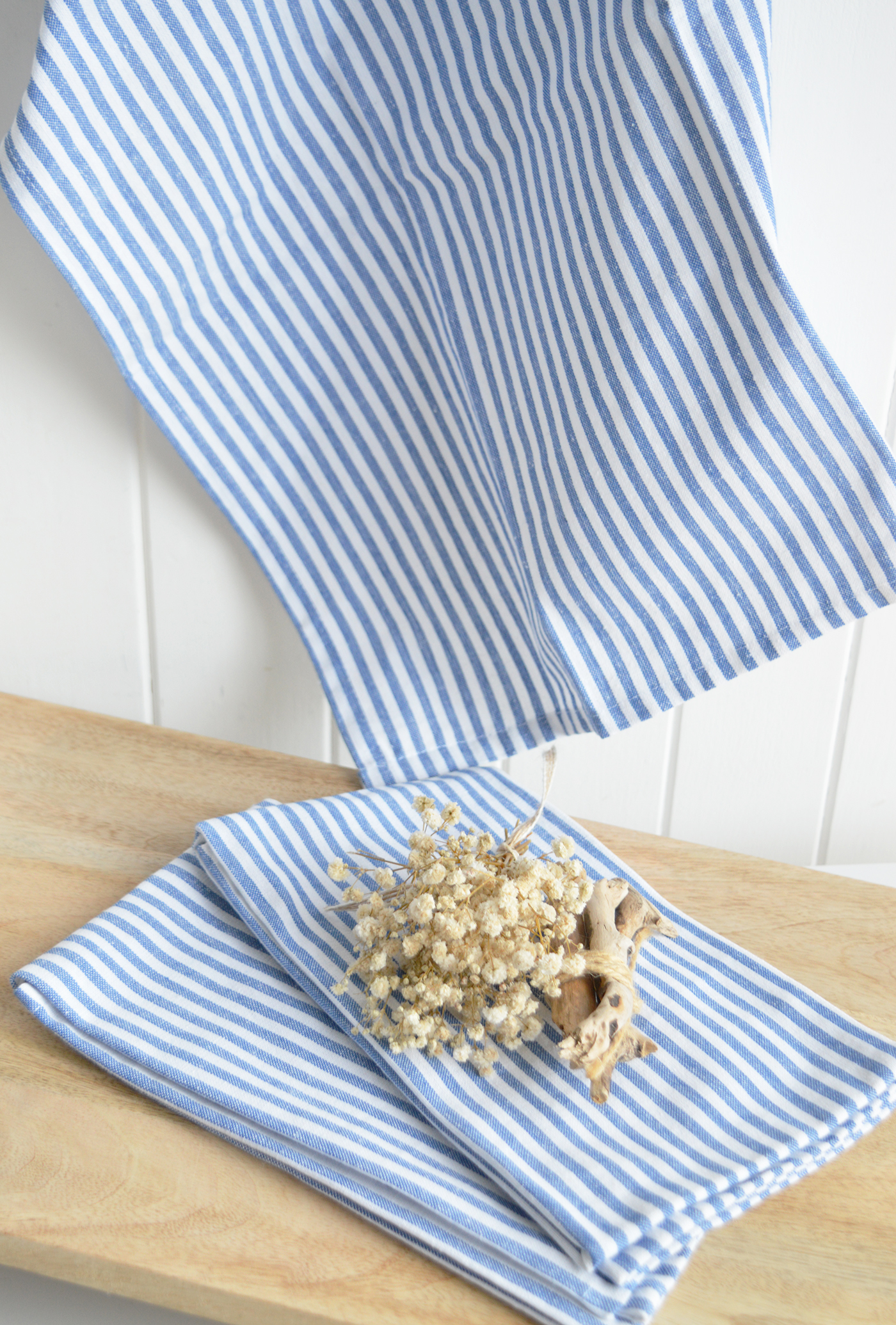 Ideal in New England country and coastal interiors, the blue and white stripe tea towels and napkins