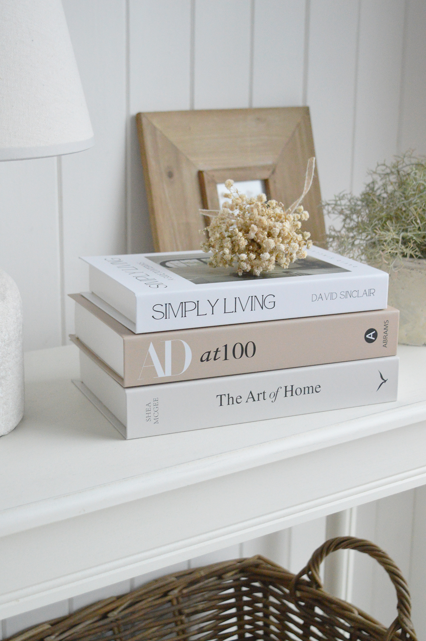 Minimal neutral home decor with decorative books styled on a console table in a coastal home