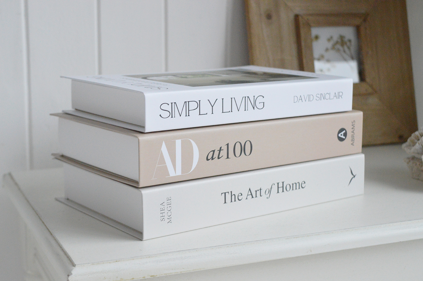 Neutral cardboard decorative books styled on shelving in a New England inspired home