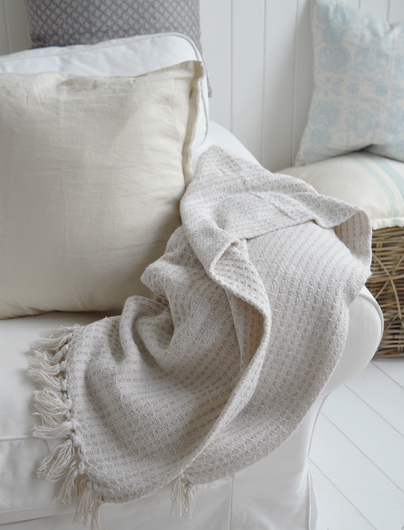The white Camden throw draped casually over a white sofa in a Cape Cod styled interior