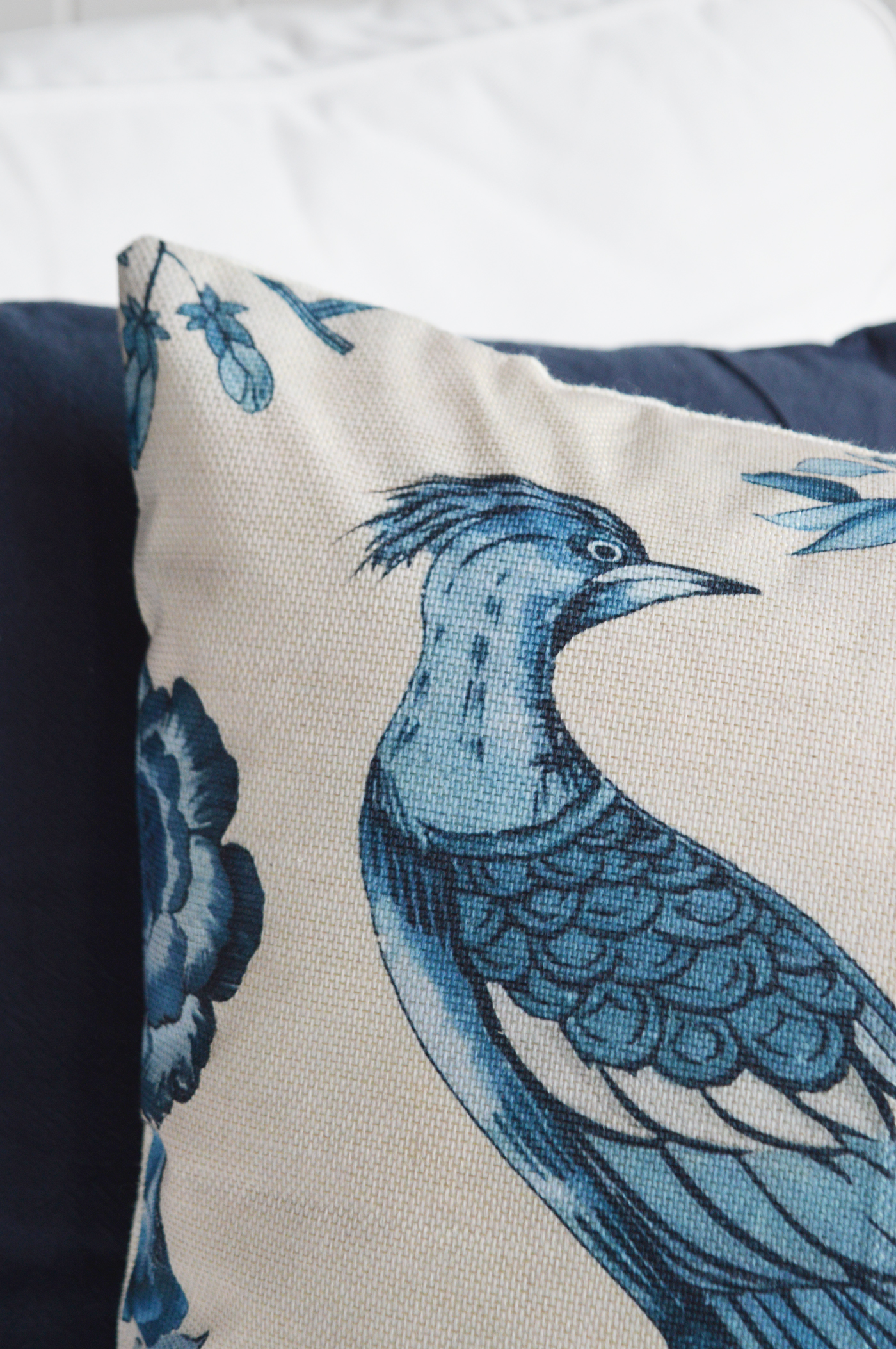 The Bluebird Bay Cushion Cover is a beautifully designed blue cushion featuring an elegant bird and botanical print on textured linen-look fabric, bringing timeless New England charm and relaxed coastal style to sofas, armchairs and bedrooms.