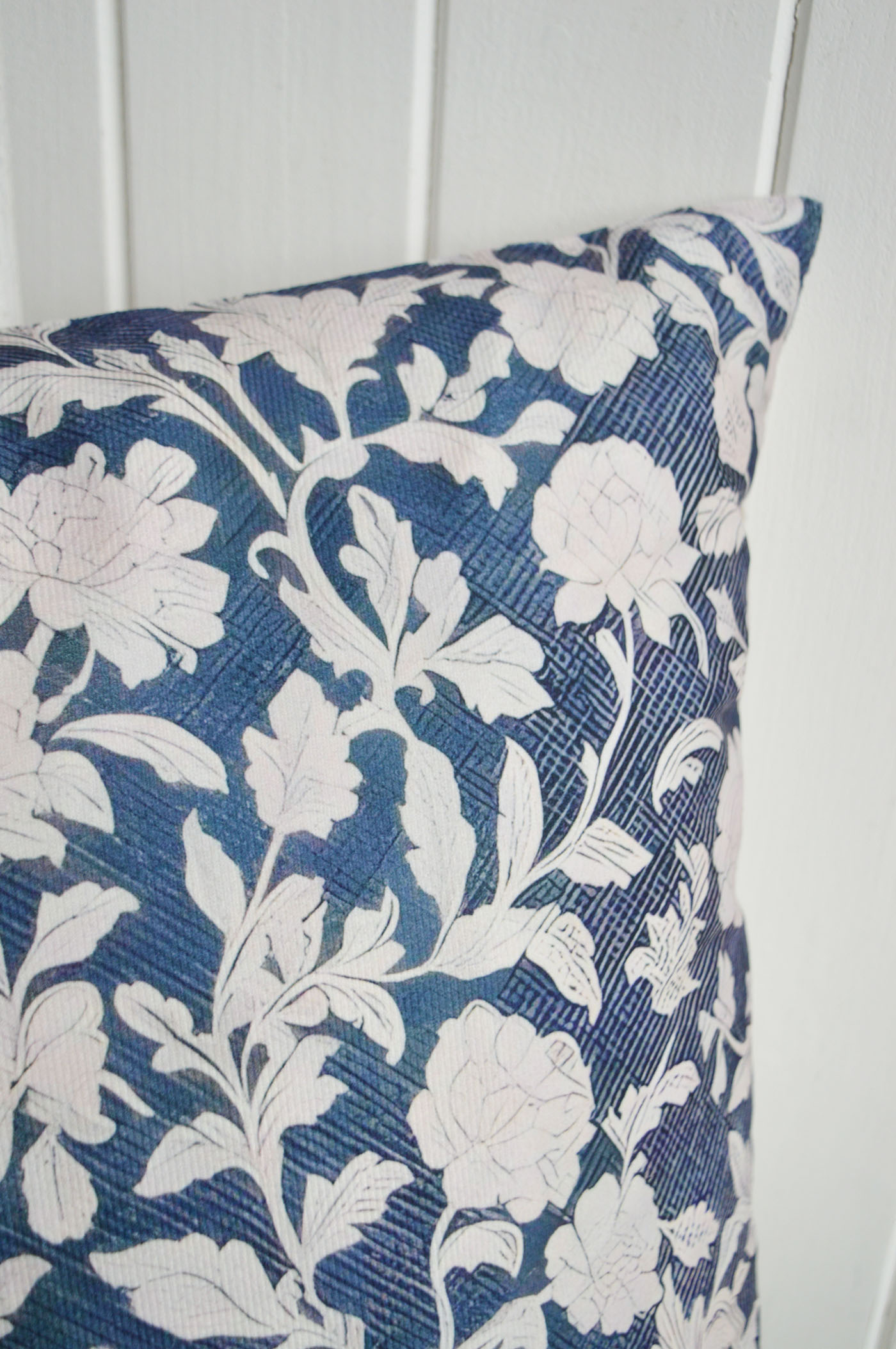 Elegant ivory florals layered over rich navy tones give the Ridgefield cushion cover a timeless Hamptons feel, perfect for coastal interiors and sophisticated New England styling.