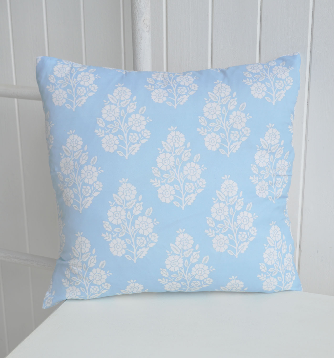 Soft blue tones and delicate white florals bring a fresh New England feel to this timeless cushion cover.