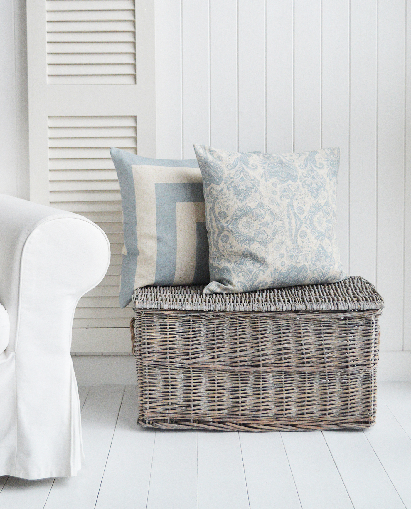 the large windsor grey lidded basket in simple setting of a living room with cushions for texture and warmth