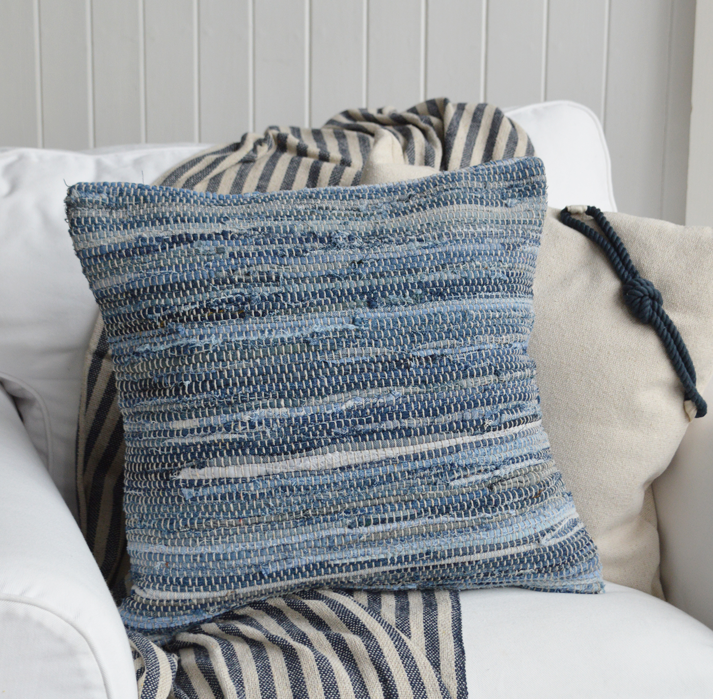 Textured blue cushion on white sofa, perfect for coastal beach interiors decor.