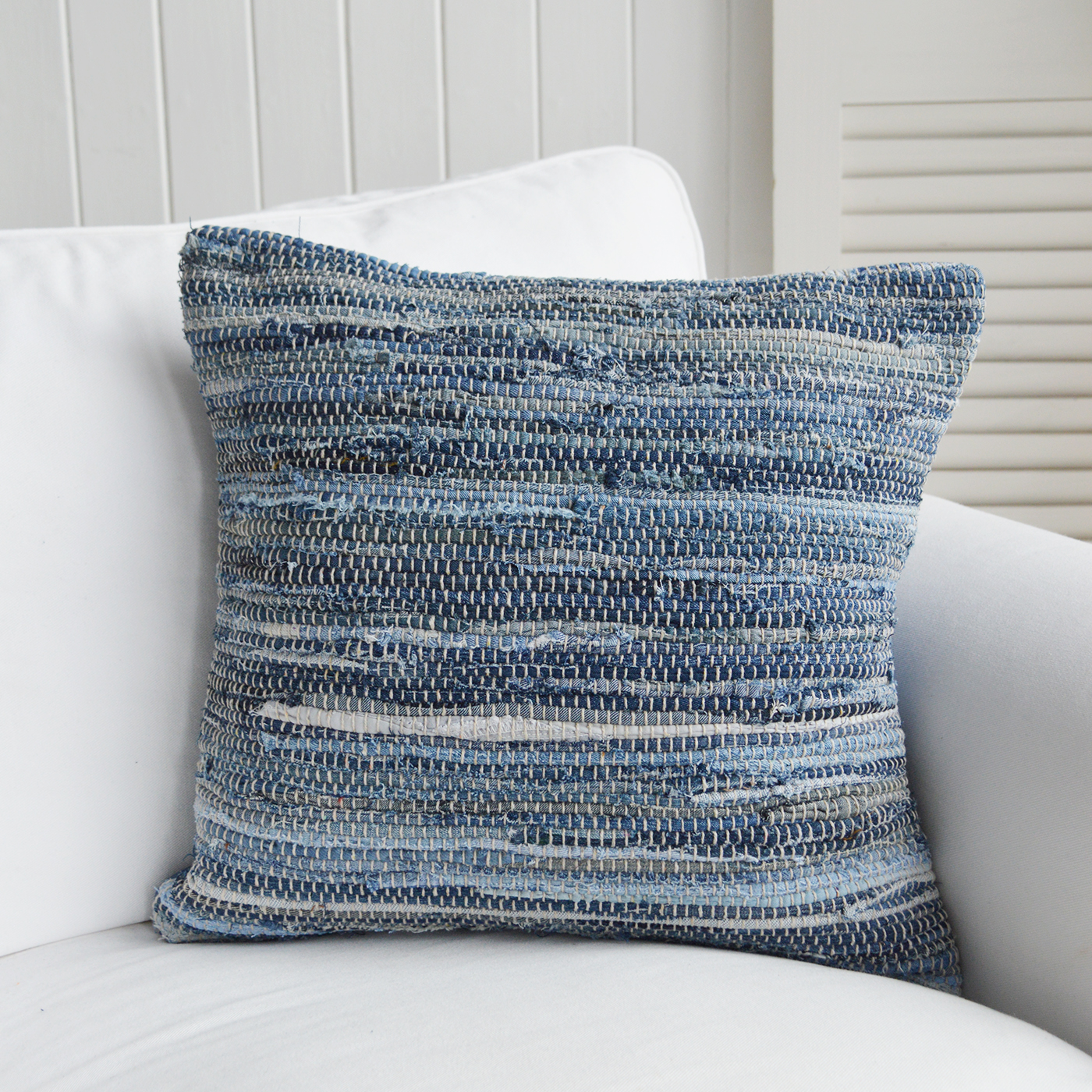 Nautical-themed cushion enhancing a light and airy coastal beach living room.