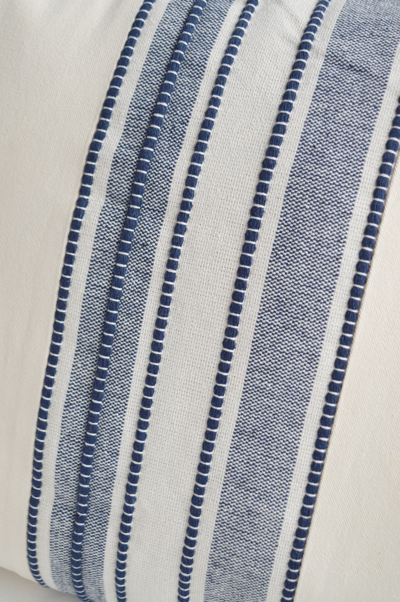 A woven navy stripe adds texture and character to this warm ivory coastal cushion cover.