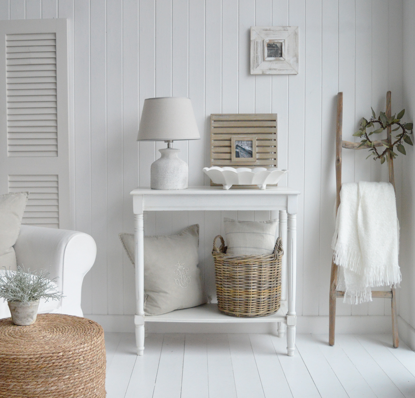 modern country furniture and home interiors in a white neutral living room  - the console table styled with white and natural pieces