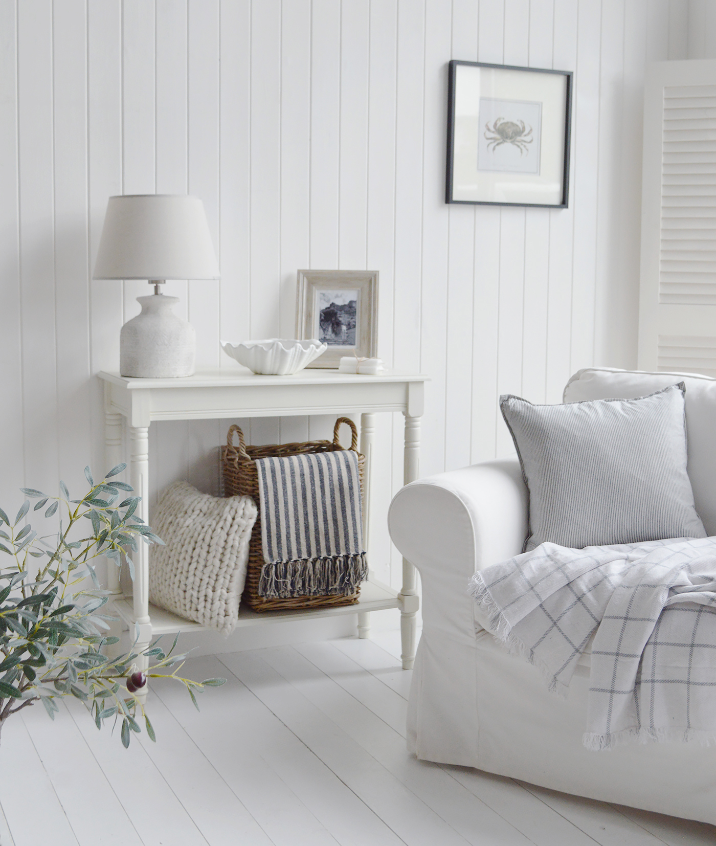 New England coastal and Hamptons inspired living room interior with blues, whites and greys with white furniture and natural baskets