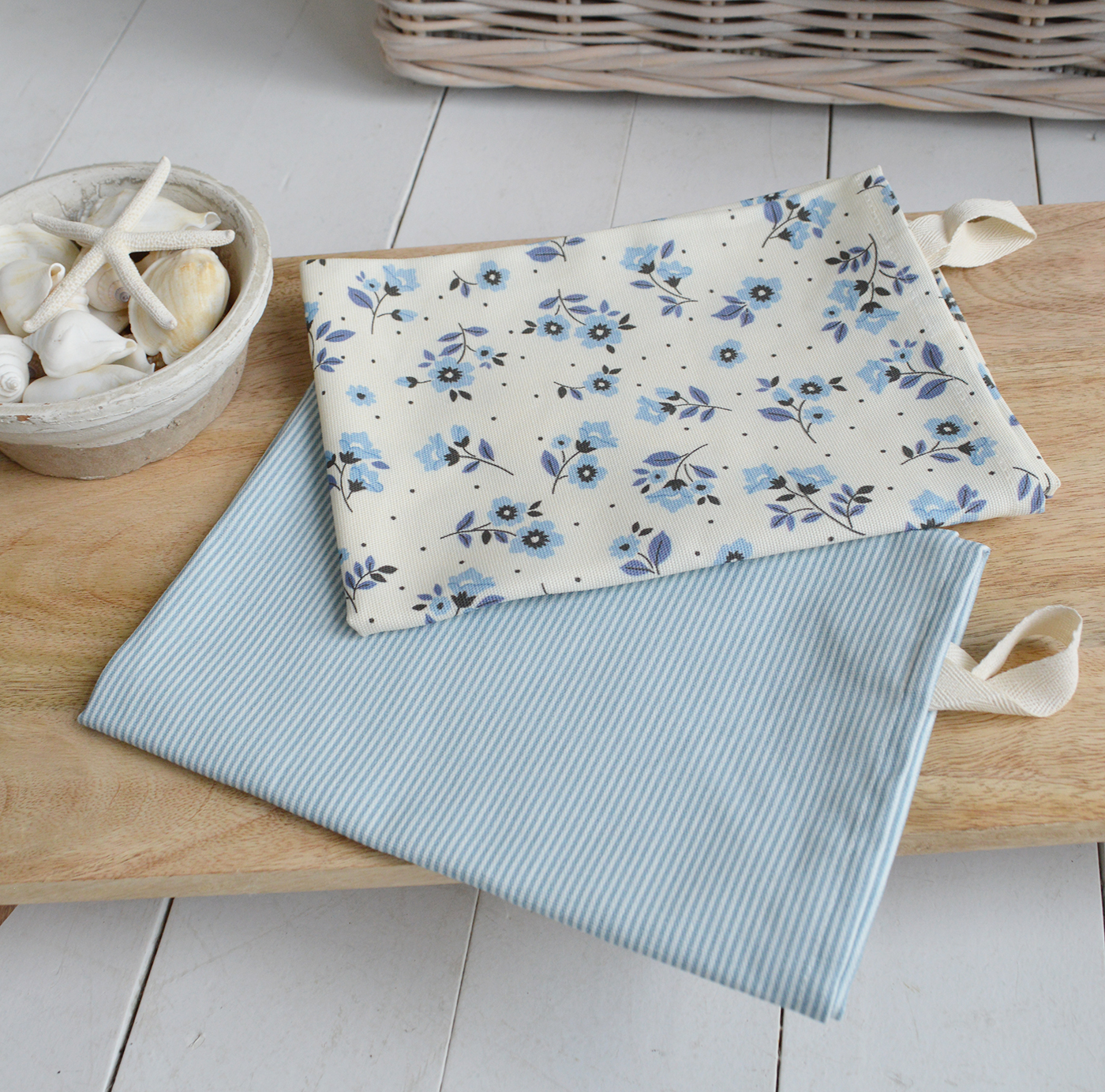 Coordinated blue and white tea towels styled with coastal kitchen decor.