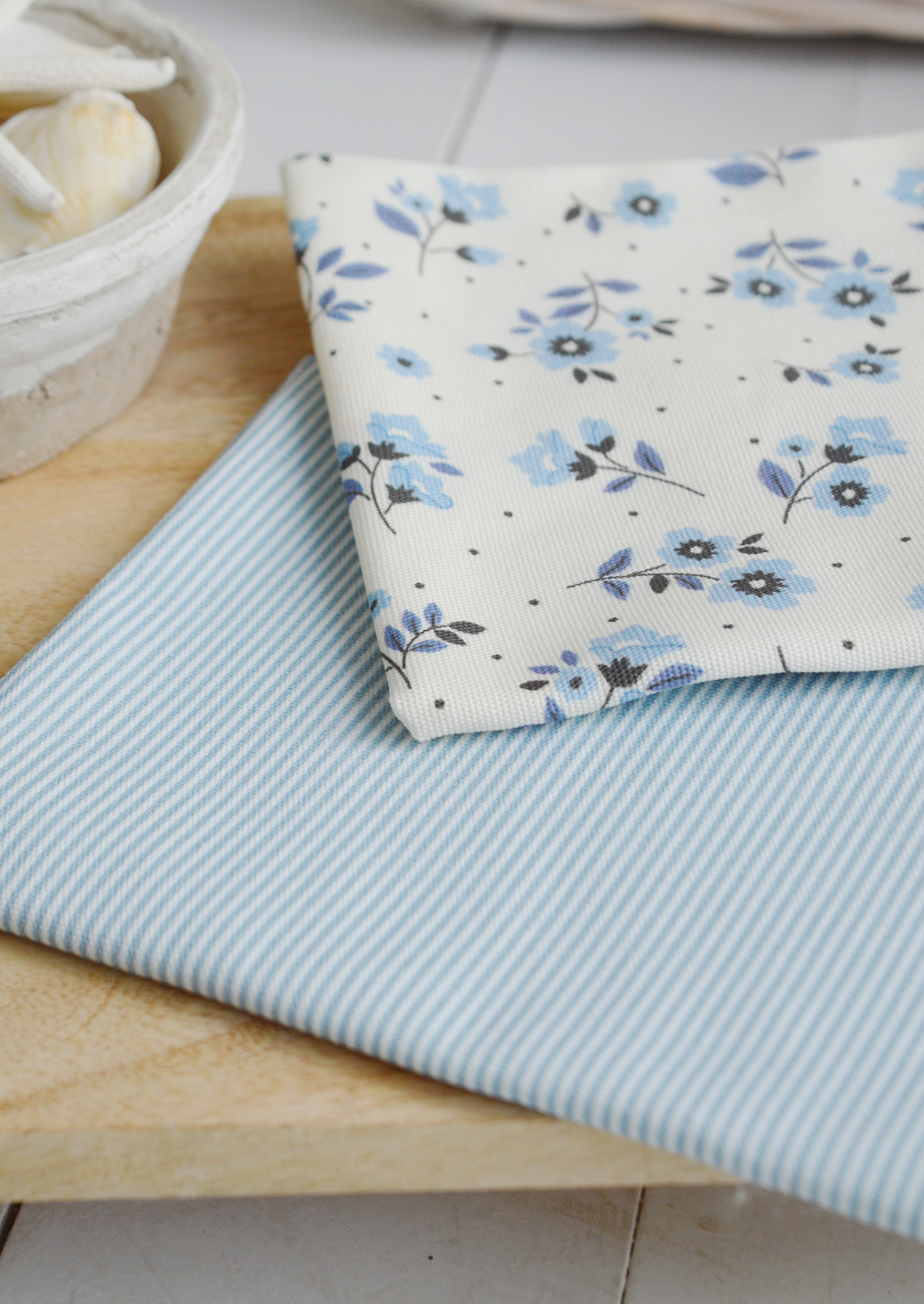 Sky blue and white striped Piermont tea towel styled in a coastal kitchen, in soft blue tones adding charm to a New England-style interior