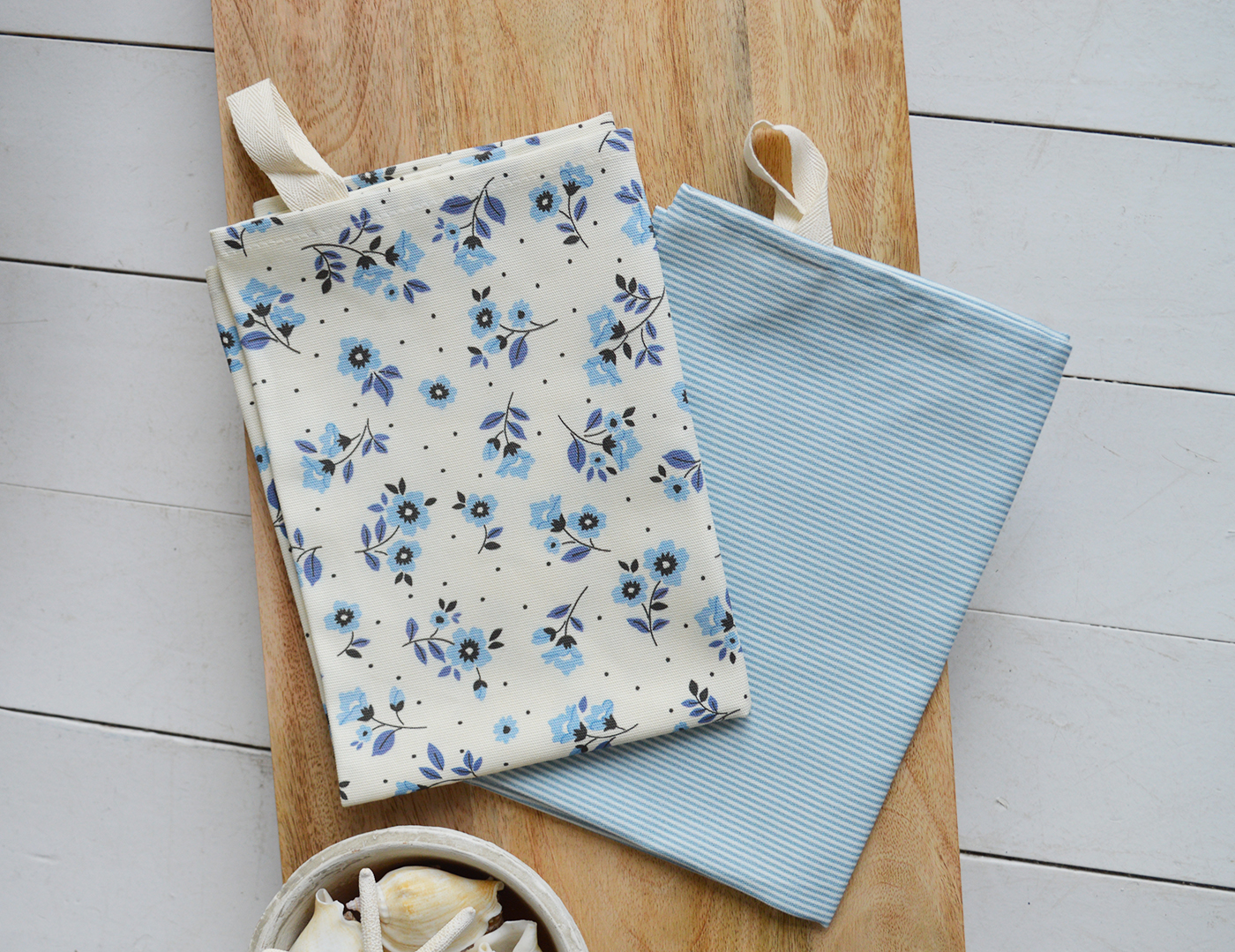 Hamptons-inspired tea towels folded neatly on a kitchen bench.