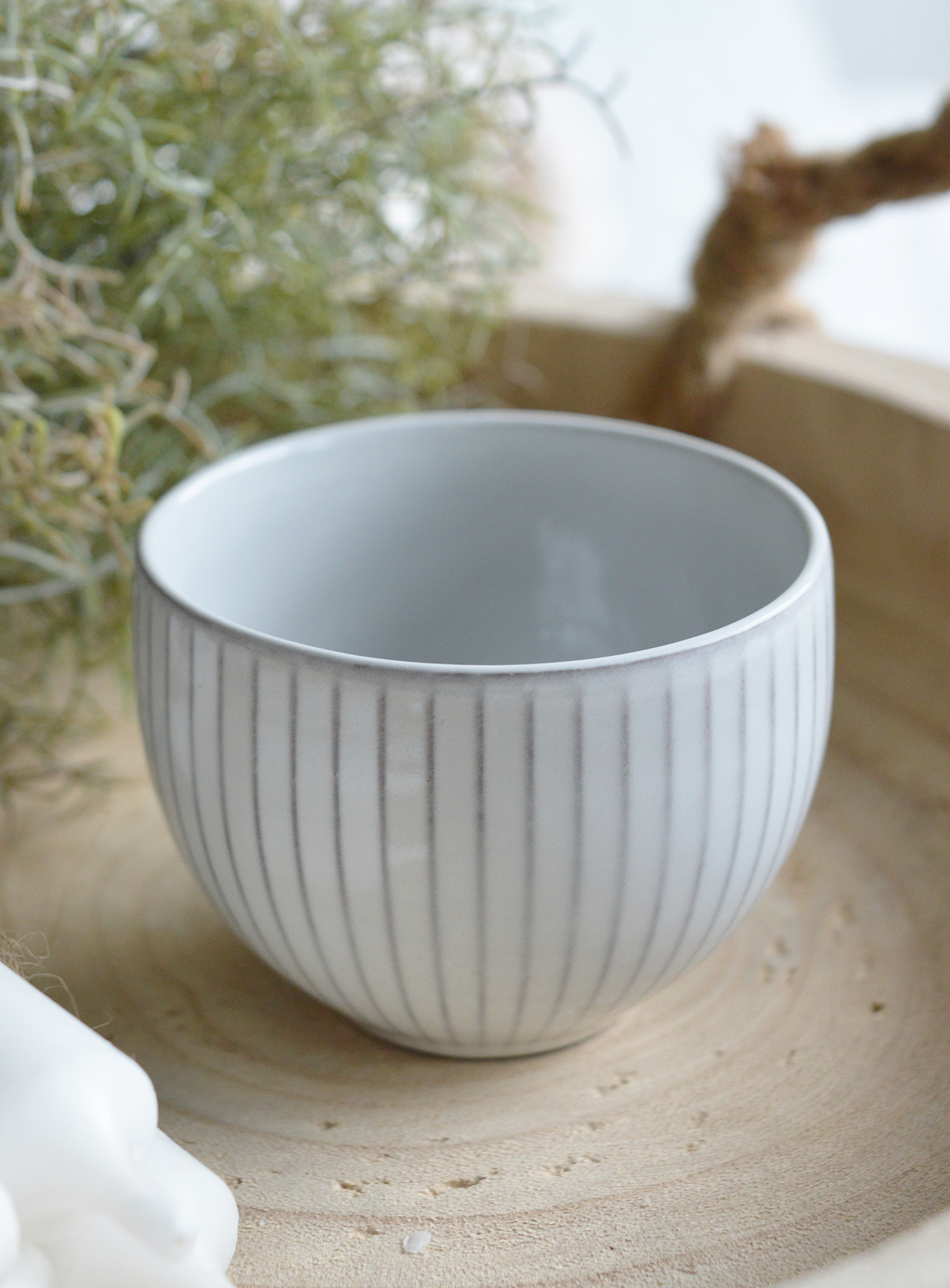 Sitting atop a weathered farmhouse table, the bowl’s muted grey tones blend effortlessly with linen napkins and antique silverware.
