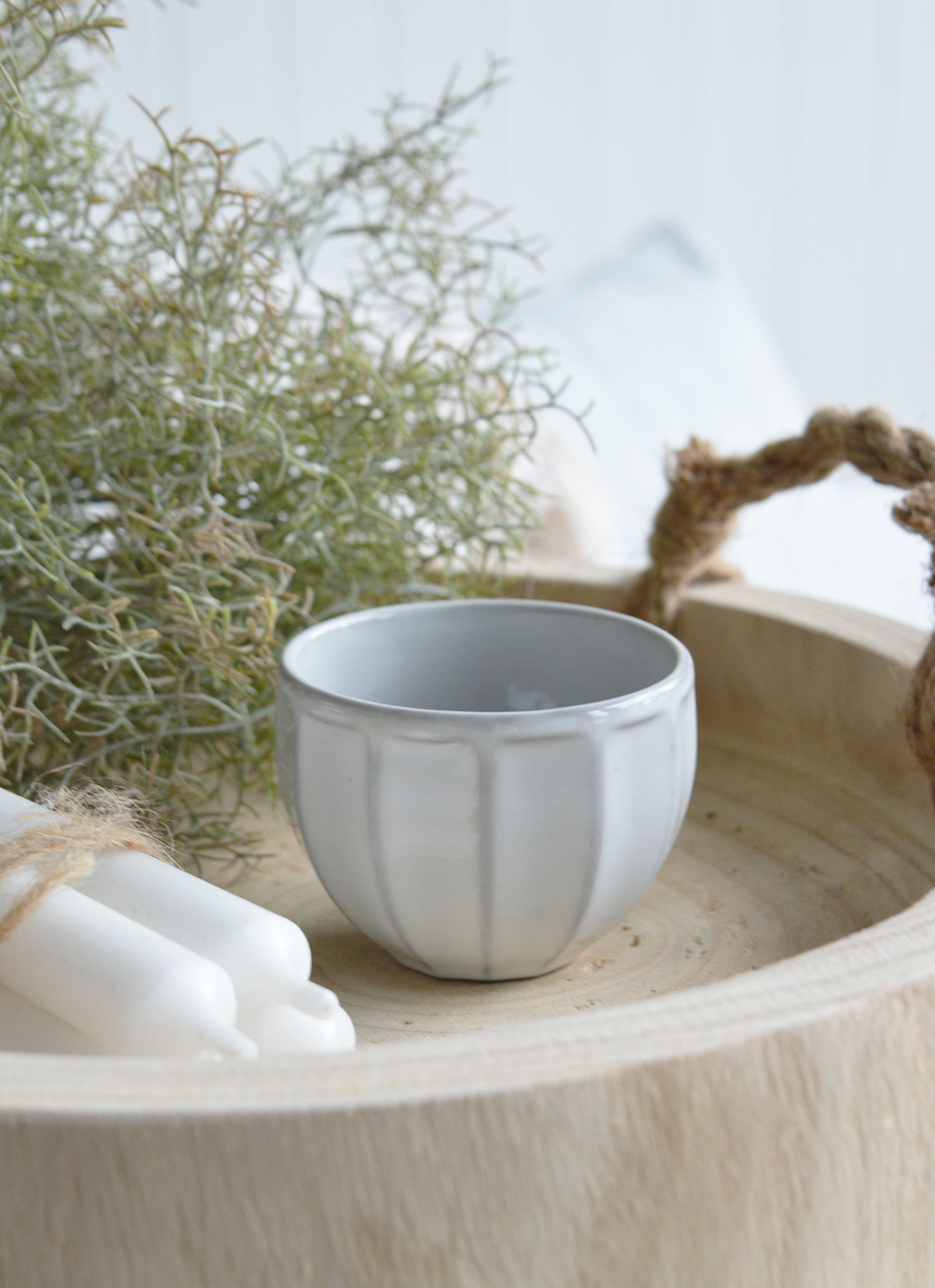 Nestled on a coffee table tray, it balances rustic and refined elements, holding smooth beach stones or dried lavender sprigs.