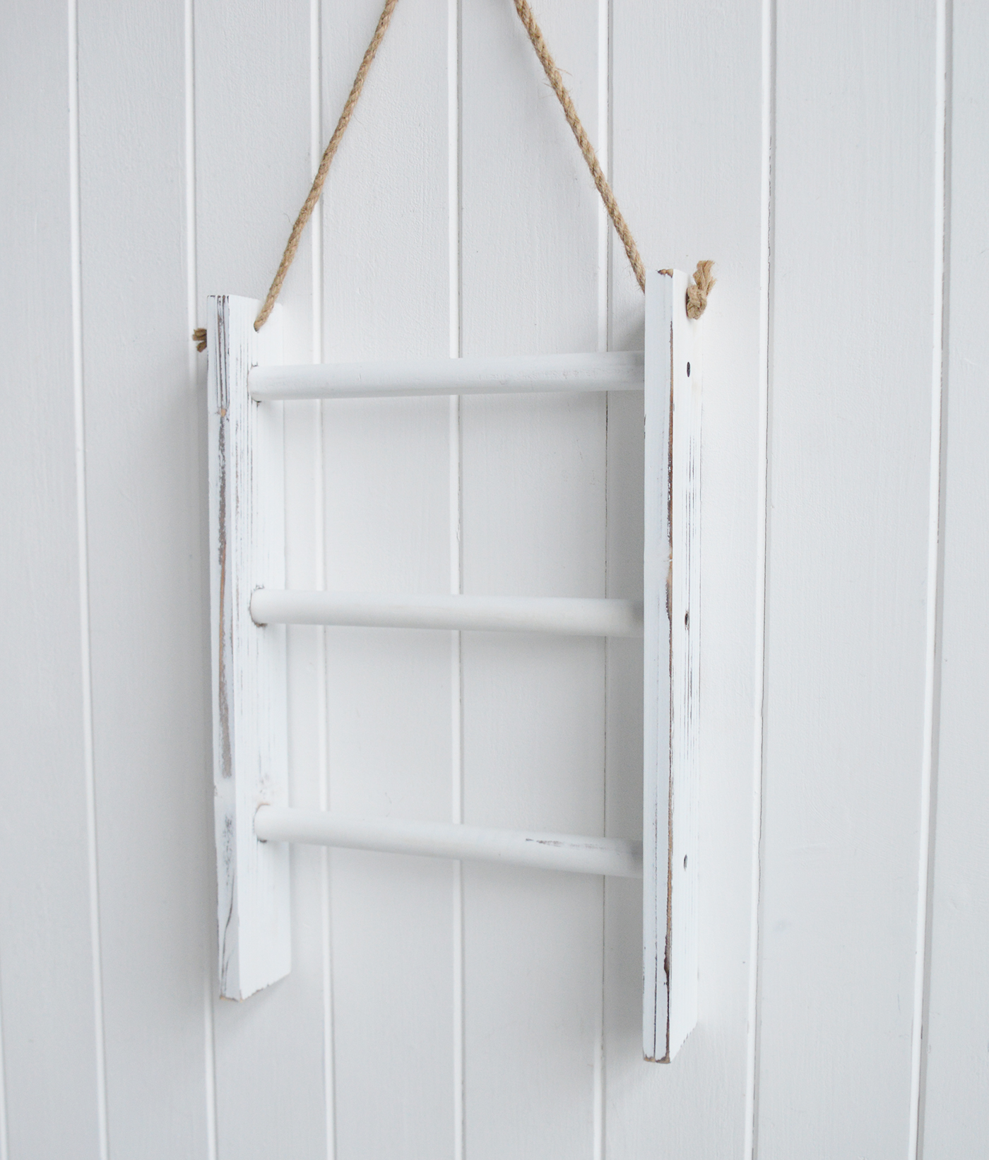 Finished in distressed white wood with natural rope detailing, this decorative wall ladder adds texture to neutral interiors and beach house décor.