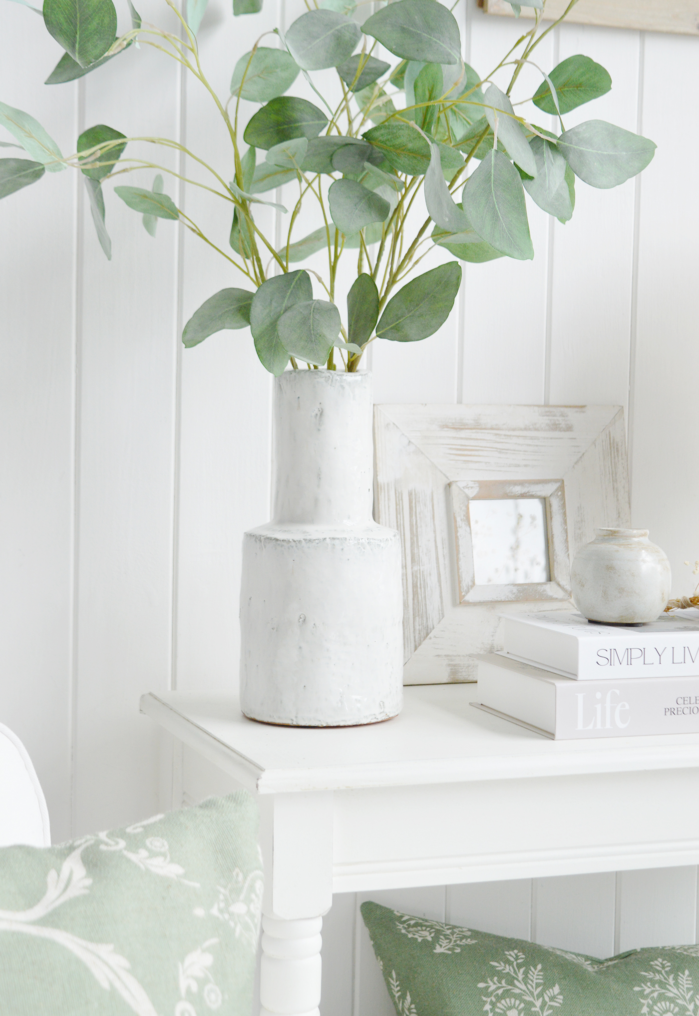 The beauty of a well-styled home often comes from creating balance between structure and softness. Here, sculptural ceramics, layered decorative frames and delicate greenery combine to bring texture, height and visual interest to the space. The muted palette allows each element to complement rather than compete, resulting in a look that feels refined, harmonious and effortlessly timeless. By incorporating natural forms alongside handcrafted finishes, this arrangement demonstrates how carefully chosen accessories can add character, warmth and a sense of quiet sophistication to any interior.