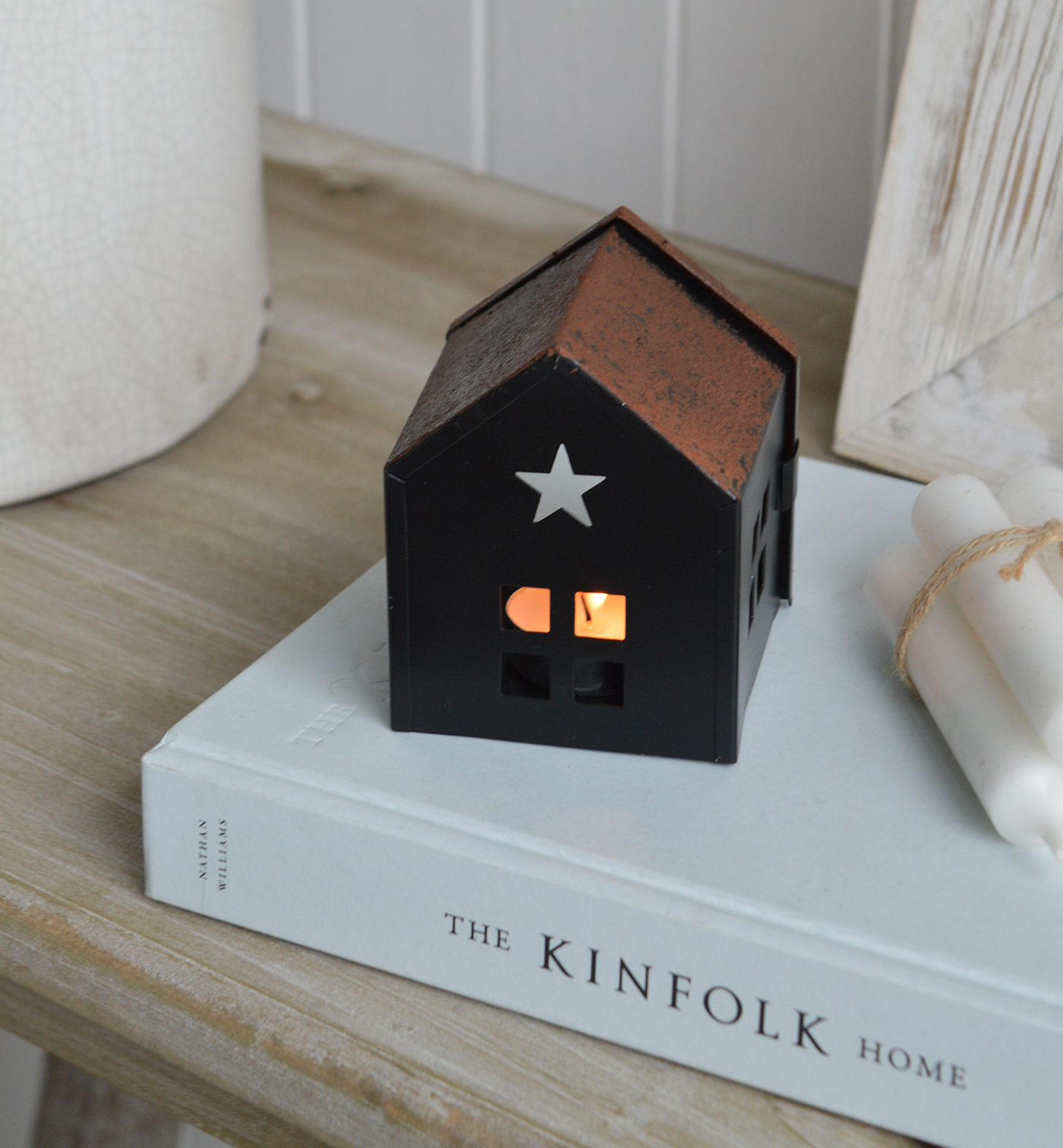 As the tea light flickers inside, the glow escapes through the windows, doors, and star-shaped cutout, casting enchanting shadows