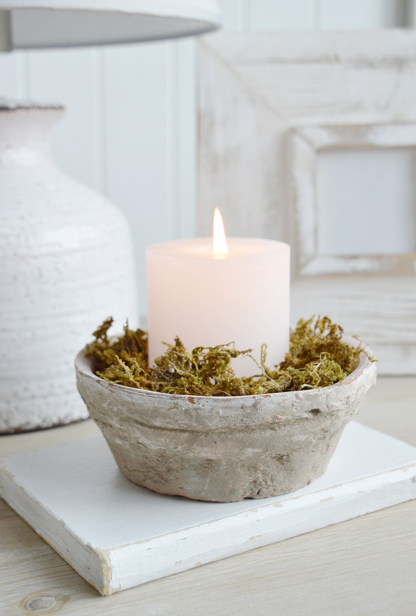 The terracotta rustic white bowl as a candle holder filled with moss for a natural look in a New England coastal or modern farmhouse home