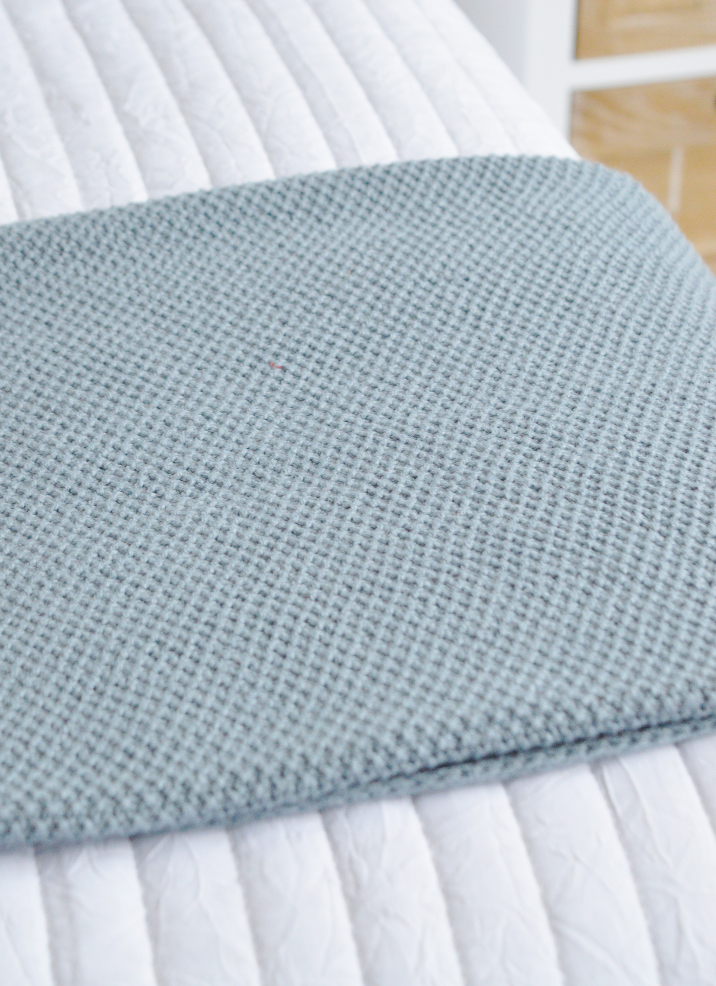 The Harrington dusky blue textural throw on a bed for modern coastal and country home interiors