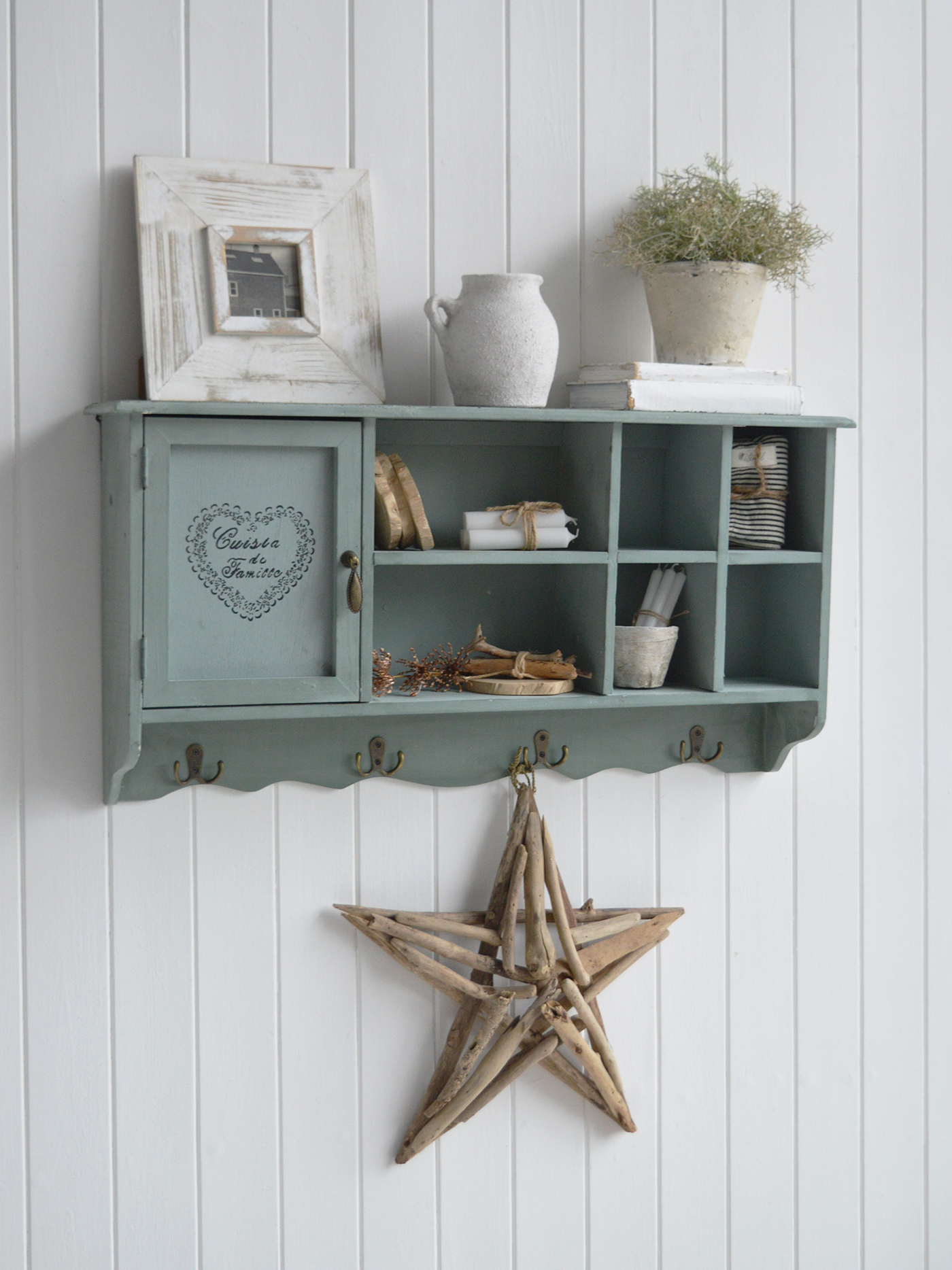 Farmhouse furniture and interiors cabinet in a soft sage finish with cubby shelves, vintage door stencil, and brass hardware for rustic kitchens.