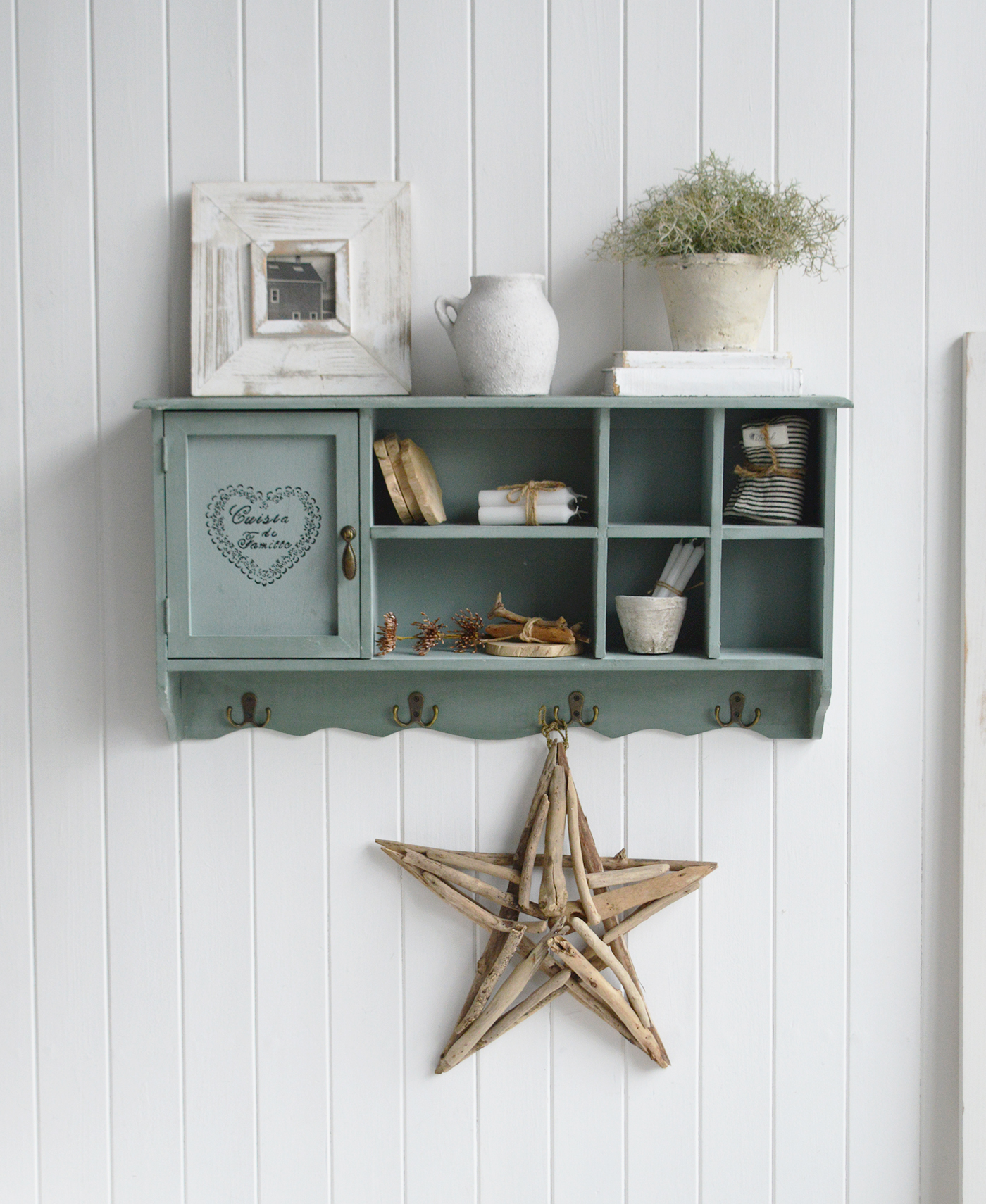 Farmhouse furniture and interiors cabinet in a soft sage finish with cubby shelves, vintage door stencil, and brass hardware for rustic kitchens.