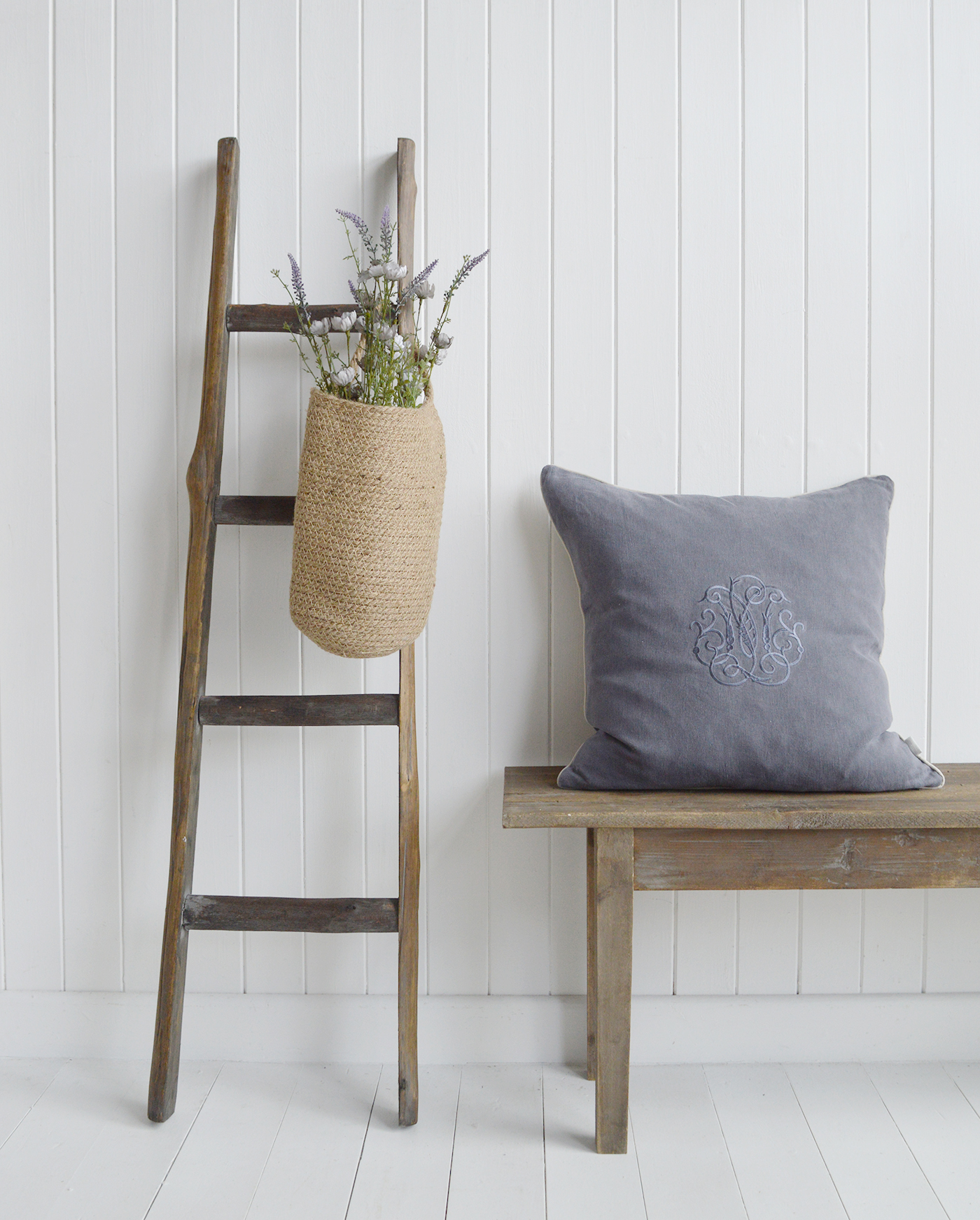 The driftwood ladder, decorated with the Campton basket, filled with wild Blue Rose spray  alongside the Pawtucket large bench and Richmond luxurioise linen cushion for New England furniture and interiors, perfect for coastal, modern country and farmhouse homes
