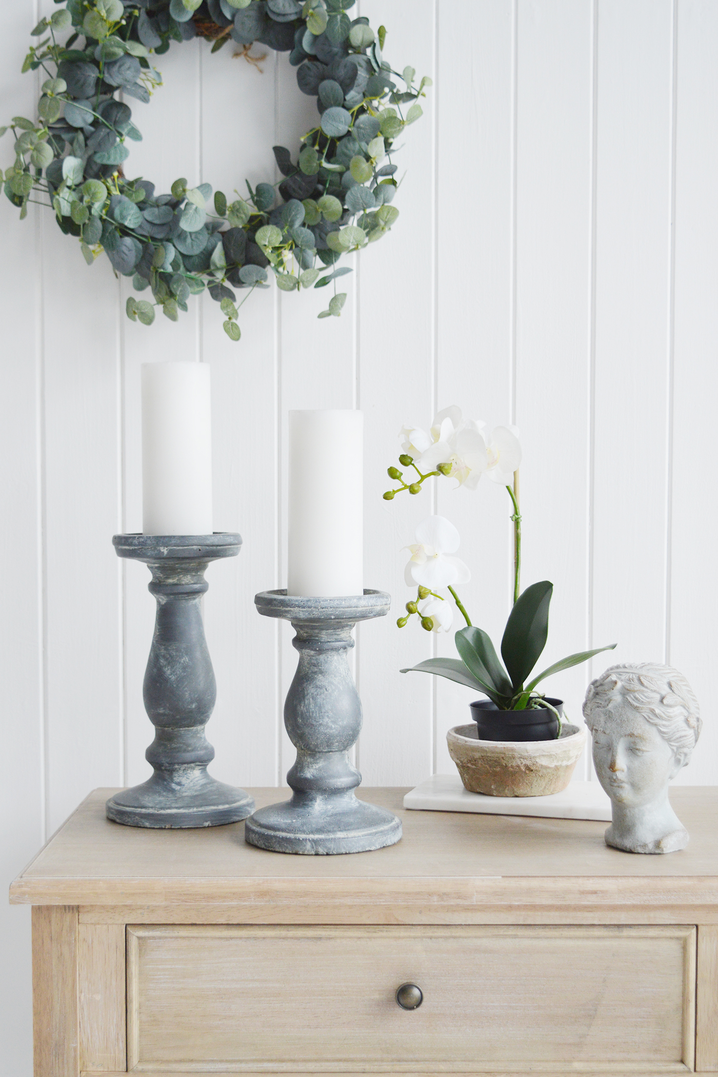 Console table styling - Candle holders, along with an artificial white Orchid, statue head, white marble tray, Eucalyptus wreath and vintage bowl