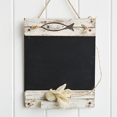 A hanging chalkboard in distressed white wood with a fish emblem, a chalk rub out and ledge to store chalk - nautical home decor