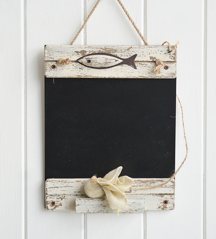 A hanging chalkboard in distressed white wood with a fish emblem, a chalk rub out and ledge to store chalk - nautical home decor