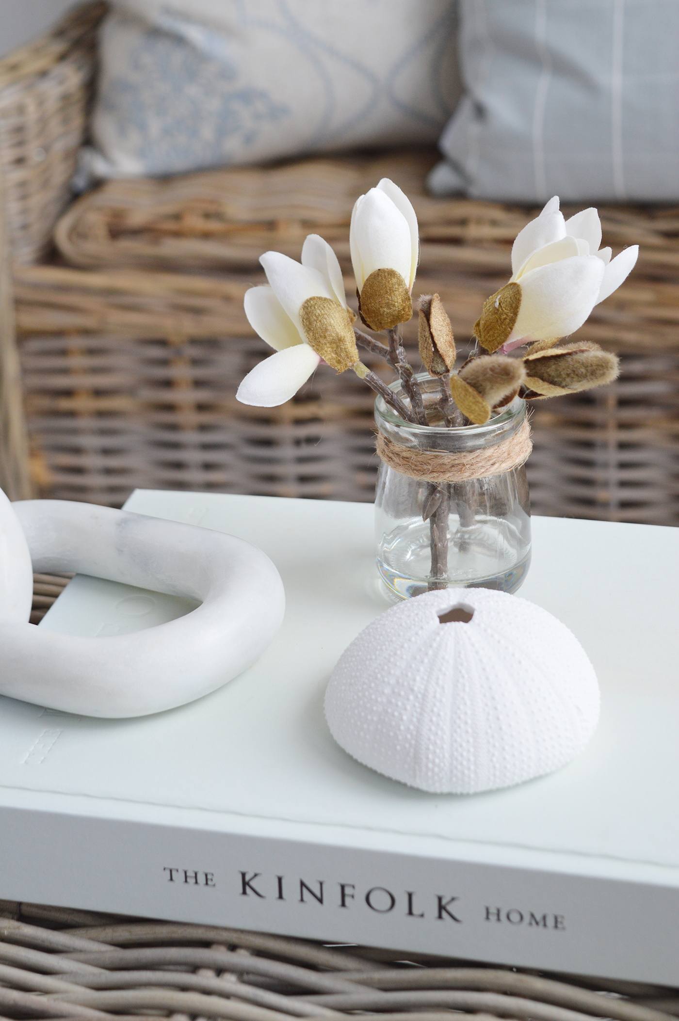 Coastal inspired interiors with the Magnolia sprig in a little bud vase with a faux white urchin