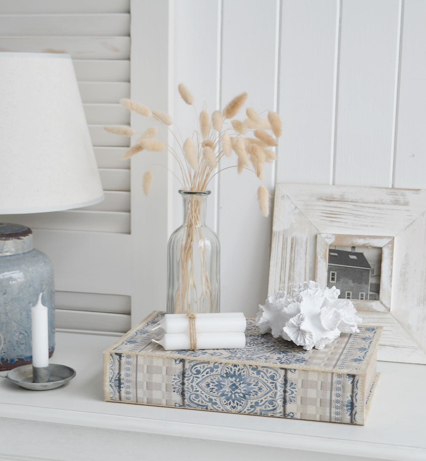 The Hartford blue grey decorative storage coffee table book shown in a coastal space with faux coral 