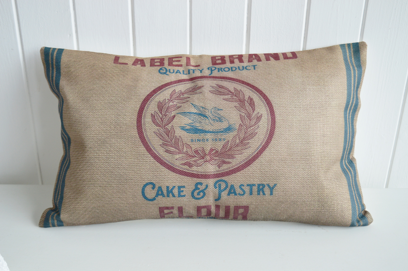 The combination of faded red, ocean blue, and hessian brown gives this cushion a relaxed, antique feel.